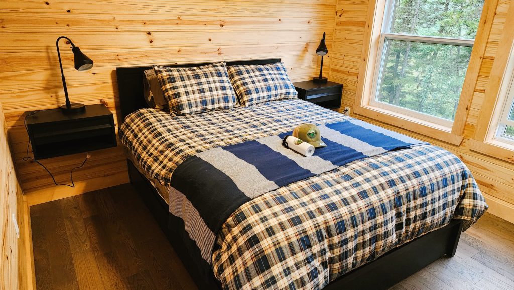 Plush queen bed in quiet wilderness bedroom of Newfoundland lodge