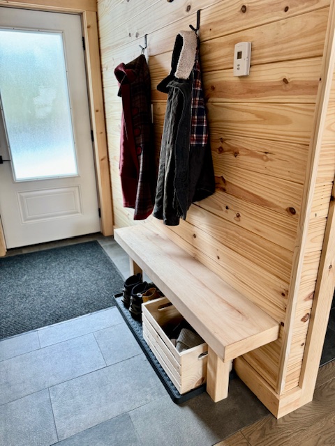 Newfoundland wilderness lodge guest entry area with coat hooks and boot trays for guest's outdoor gear